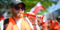 Streikende Person mit Warnweste und Sonnebrille auf einem Streik von IG BAU
